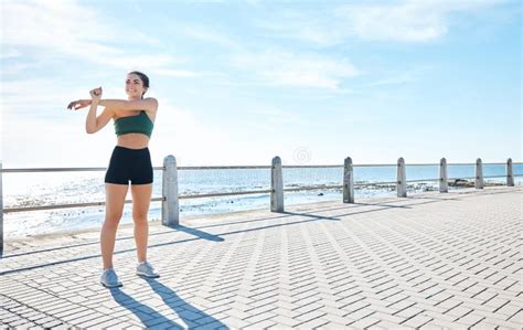 Fitness Woman And Stretching Arms At The Beach For Running Exercise