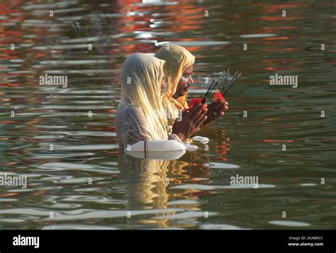 Hindu Devotees Perform Rituals And Offer Prayers To The Sun God On The