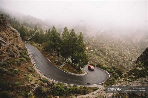 Car Driving On Winding Road In Mountains On Foggy Day — Drive Travel