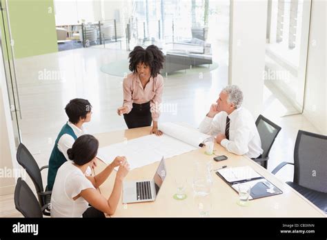 Project discussions amongst employees in boardroom Stock Photo - Alamy