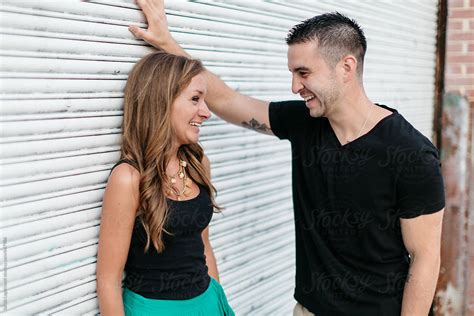 Young Attractive Couple Laughing At Each Other In An Urban Setting By Stocksy Contributor