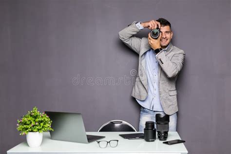 Young Photographer Man Standing With Camera In Modern Office Stock