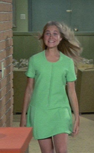 A Woman In A Green Dress Walking Down A Hallway