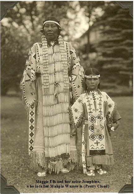 An Old Photo Of Two Native Americans Standing Next To Each Other In The