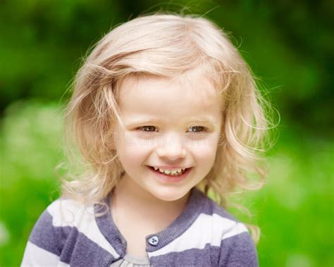 Closeup Portrait Of A Smiling Blonde Little Girl With Curly Hair Stock