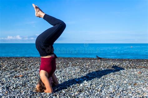 Doing Yoga Exercises Outdoors At The Beach Pier In Stone Beach Stock