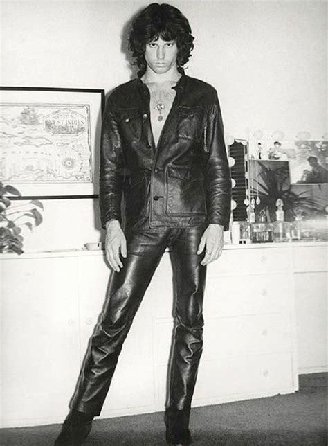 A Black And White Photo Of A Man In Leather Pants Standing Next To A