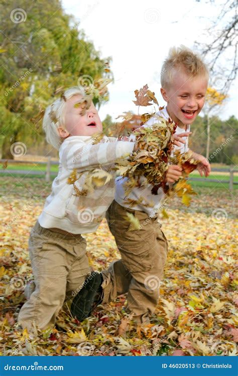 Two Young Children Throwing Fall Leaves Outside Stock Image Image Of
