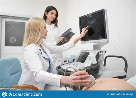 Doctors Doing Ultrasound Diagnosis Of Pregnant Woman Stock Image