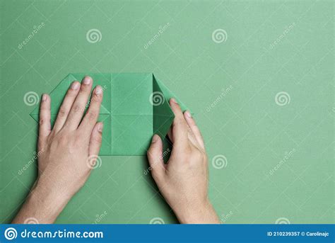 Young Hands Folding Paper To Make An Origami Figure Green Paper And