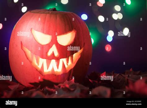 Scary Lighted Jack O´lantern Halloween Carved Pumpkin On Bokeh Dark