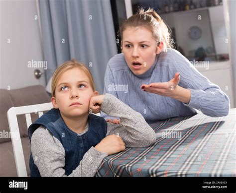 Serious Adult Mother Scolding Her Teenage Daughter At Home Stock Photo