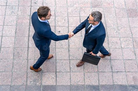 Handshake With Partner In The City For Greeting Business Men In Suit