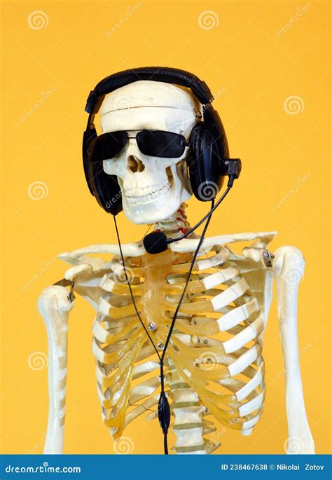 A Human Skeleton Wearing Headphones With A Microphone Stock Photo