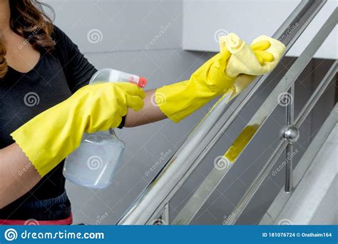 The Housewife Is Happy In A Rubber Glove Wipe The Dust With A Spray While Cleaning Wipe Railaban