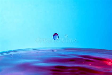 Drop Of Water Falling In Blue Water And Blue Background Stock Image