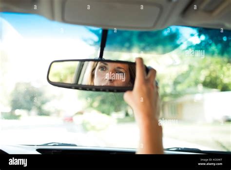 Woman Adjusting Rear View Mirror In Car Stock Photo Alamy