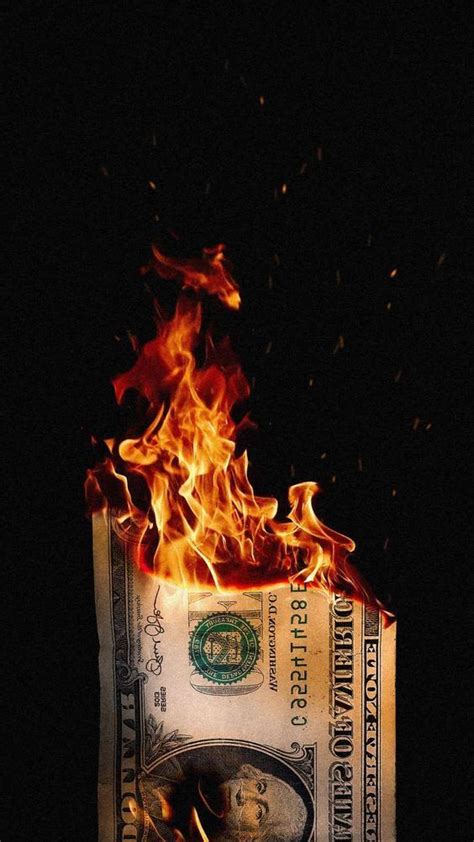 A Burning Dollar Bill In The Dark With Fire Coming Out Of Its Back