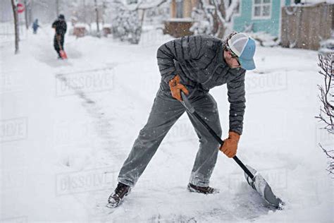 Man Shoveling Snow From Street Stock Photo Dissolve