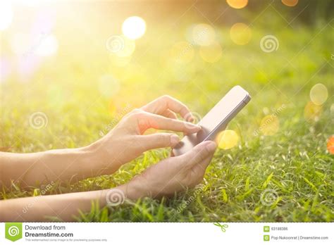 Woman Using Mobile Smart Phone Outdoor In The Sunrise On Nature Stock