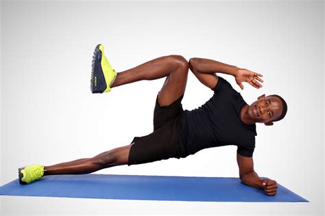 Fit Man Doing Side Plank With Knee Crunch On Yoga Mat
