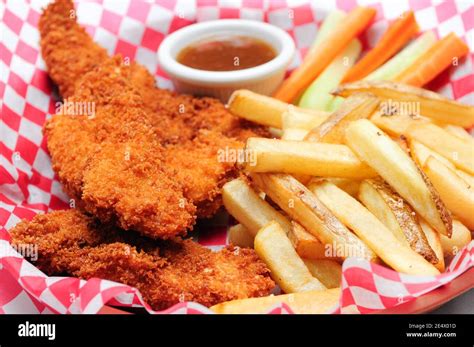 Breaded Chicken Strips With French Fries And Dipping Sauce In A Stock