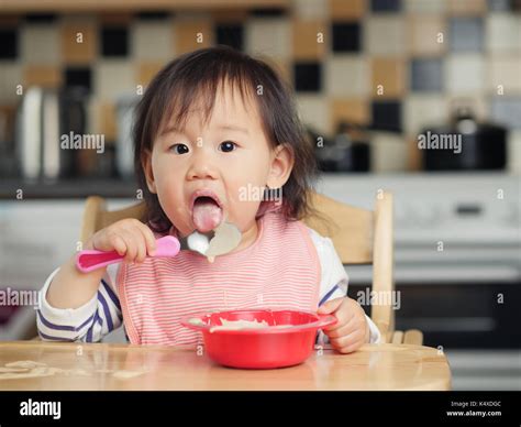 Baby Girl Eating Yoghurt At Home Stock Photo Alamy