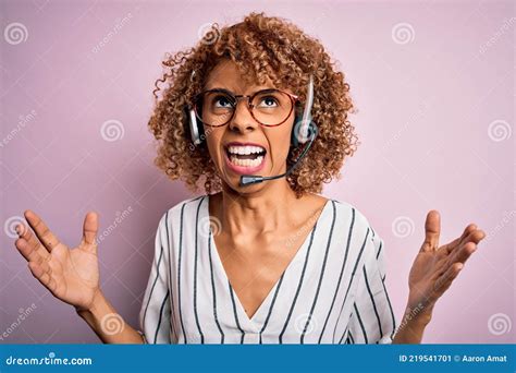 African American Curly Call Center Agent Woman Working Using Headset Over Pink Background Crazy