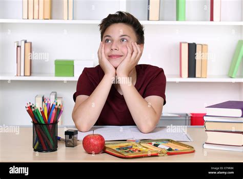 Young Boy Day Dreaming At School While Doing Homework Stock Photo Alamy