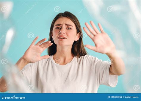 Upset Crying Girl Sadly Looking In Camera While Choking On Plastic Over Colorful Background