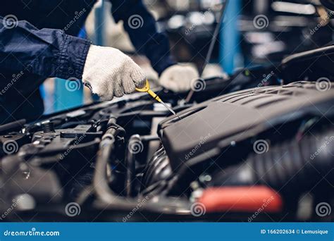 Auto Car Repair Service Center Mechanic Checking Engine Oil Level