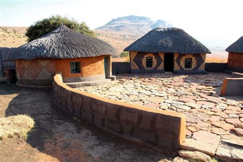 Some Huts With Thatched Roofs Are In The Middle Of An Arid Area Near