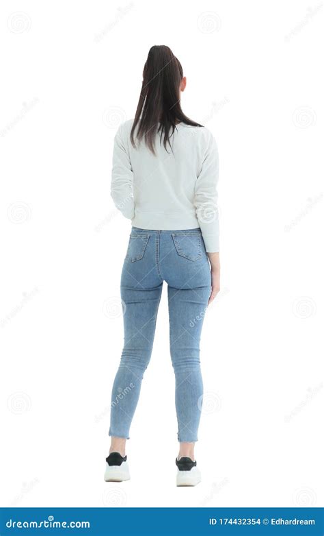 Rear View Stylish Girl In Jeans Standing In Front Of A White Wall
