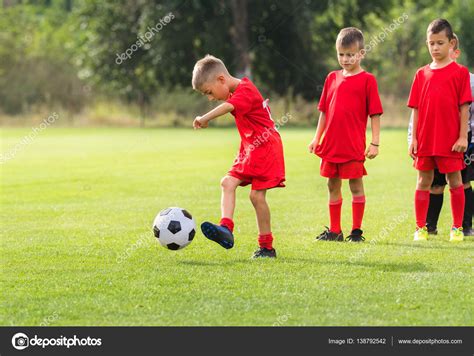Boy Kicking Soccer Ball At Training Stock Photo By ©fotokostic 138792542