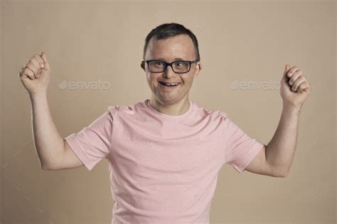 Man With Down Syndrome Celebrating Success At Nude Background Stock