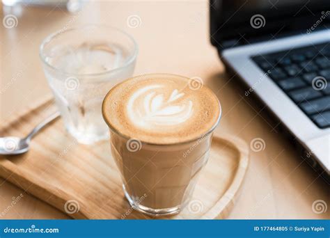 Coffee Cup Latte Art With Cake And Laptop Computer On Wooden Table In A