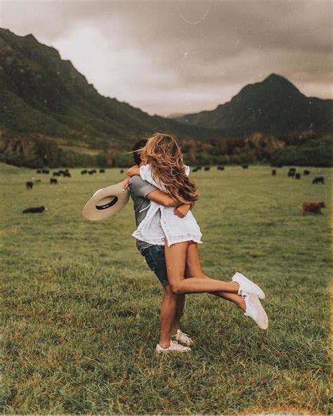 Two People Are Hugging In The Middle Of A Field