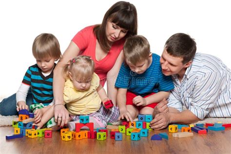 La Familia Está Jugando Con Los Niños En El Piso Foto De Archivo