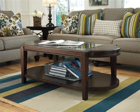 With a walnut top, solid edges, and a black steel base, let this coffee table catch the eye of any wandering guest. Ashley Northglen T768-0 Signature Design Oval Cocktail ...