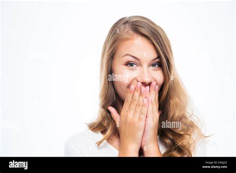 Portrait Of A Happy Young Woman Covering Her Mouth Isolated On A White Background Looking At