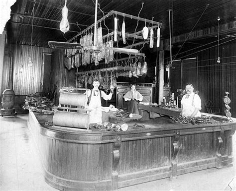 Interior Of A Local Butcher Shop With The Butchers Standing Behind A