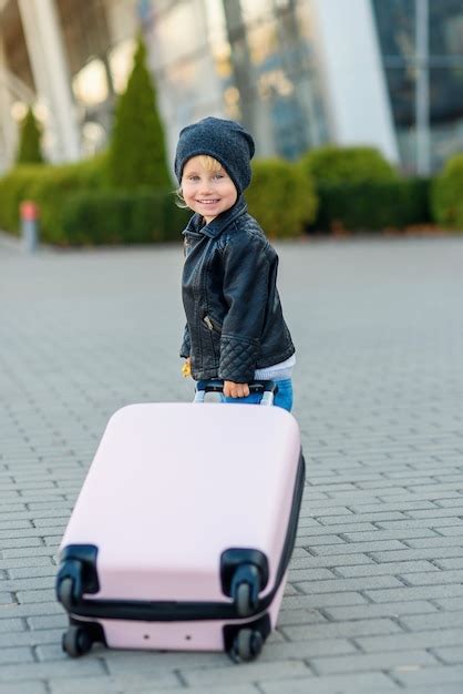 Premium Photo Cute Little Traveler Girl Pulls Pink Suitcase Towards