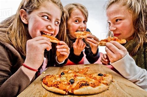 3 Teenagers Eating Pizza Stock Photo Dissolve