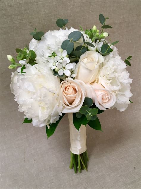 A Delicate Clutch Bouquet Made Of Peony Lisianthus Ivory Roses And
