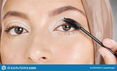 Closeup Portrait Of Muslim Woman Applying Mascara Makeup To Eyelashes