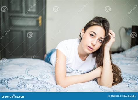 Young Woman Looking At Camera And Smiling While Lying On The Bed At