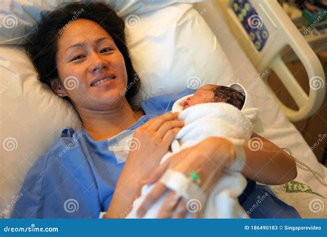 Delighted Asian Chinese Woman Holding Her New Born Baby Right After