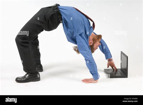 Businessman Typing While Bent Over Backwards Stock Photo Alamy