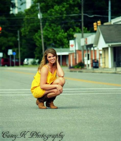 a woman kneeling down in the middle of a street