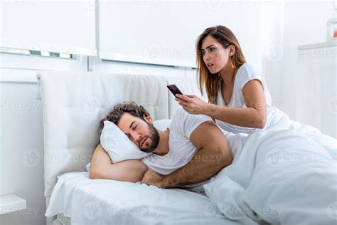 Jealous Wife Spying The Phone Of Her Partner While He Is Sleeping In A Bed At Home Shocked